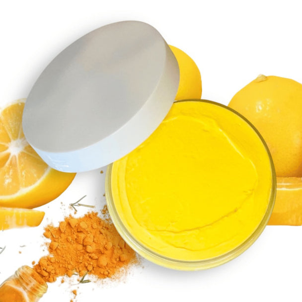 top view of brightening turmeric body butter revealing bright yellow hue from the organic turmeric and silky texture of natural moisturizer with lemons and turmeric in the background highlighting natural australian skincare.