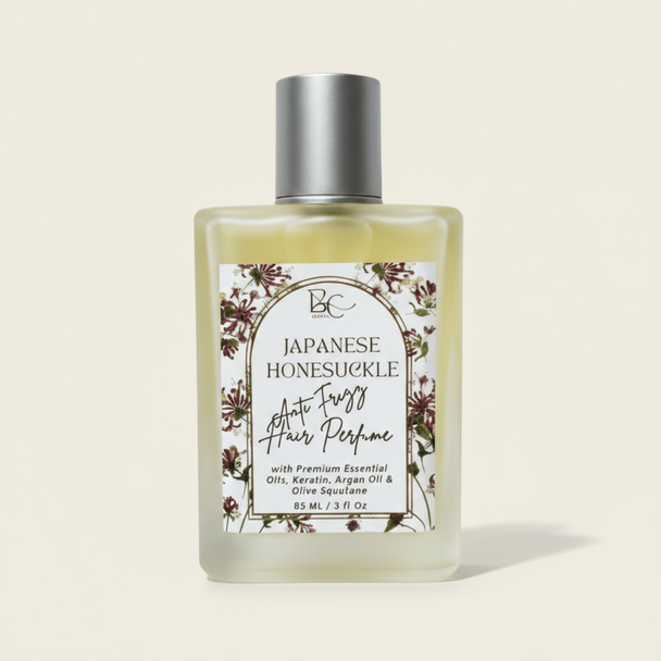 Bottle of luxury hair perfume with keratin, argan oil and Japanese Honeysuckle essential oil with floral label on a white background