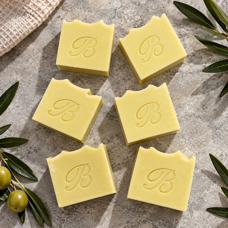 Handcrafted olive oil Castile soap bars flat lay with olive branches and green olives