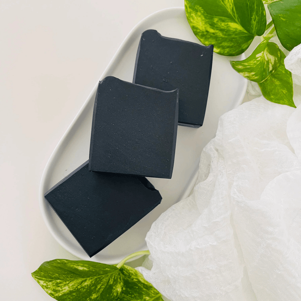 Close up of natural activated charcoal soap with tea tree and peppermint with botanicals showcasing the best of Australian organic ingredients.