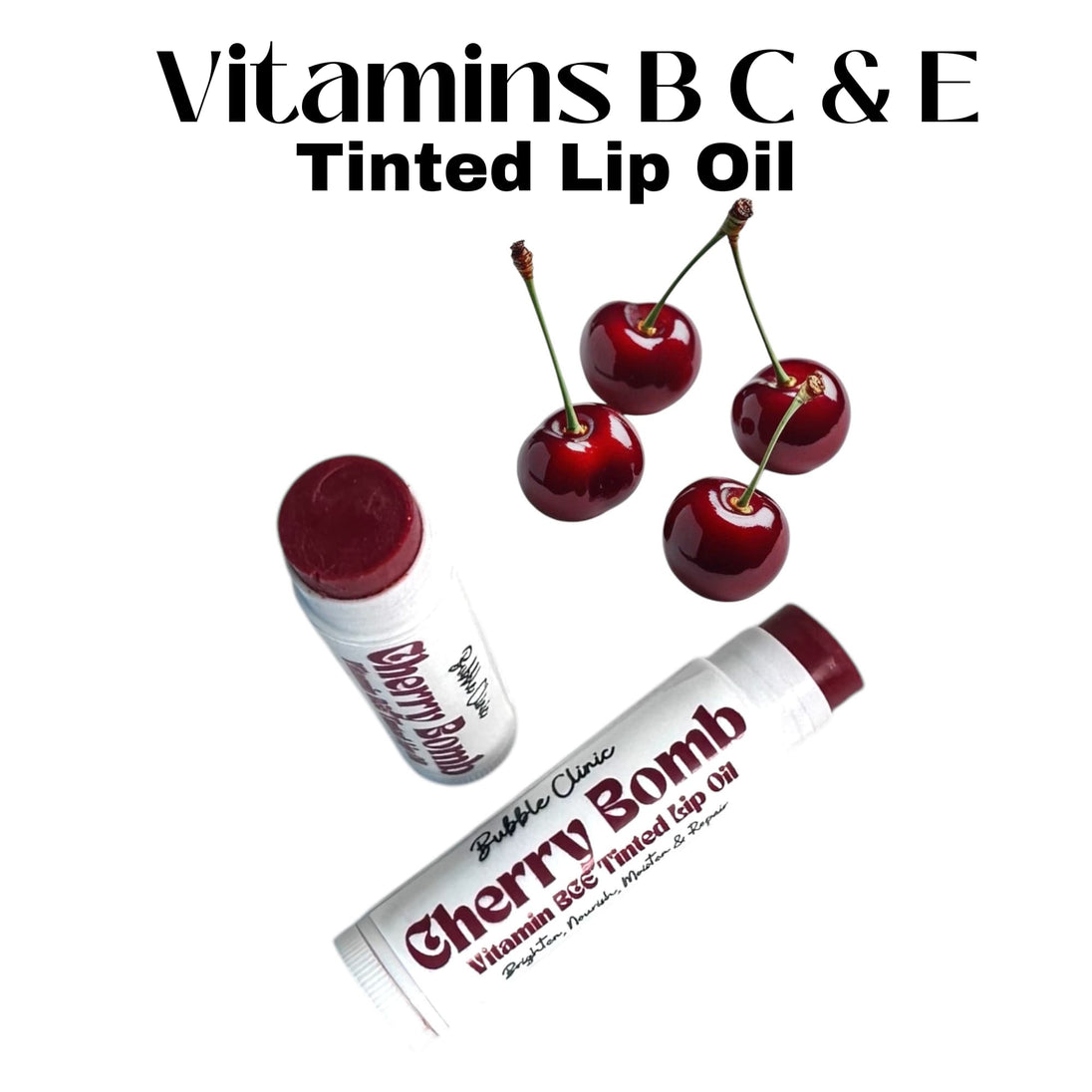 Cherry Bomb Tinted Lip Treatment Oil displayed with open tubes revealing its rich cherry-crimson hue. Four fresh cherries surround the product on a clean white background, reinforcing the natural, fruity inspiration and hydrating cherry kernel oil base.