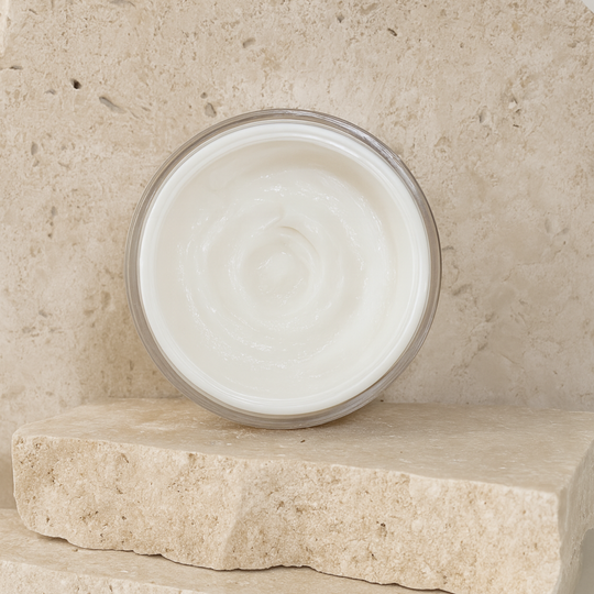 Front view of open azeluxe 20% Azelaic Acid cream revealing creamy silky consistency of the acne cream against organic stone background. 