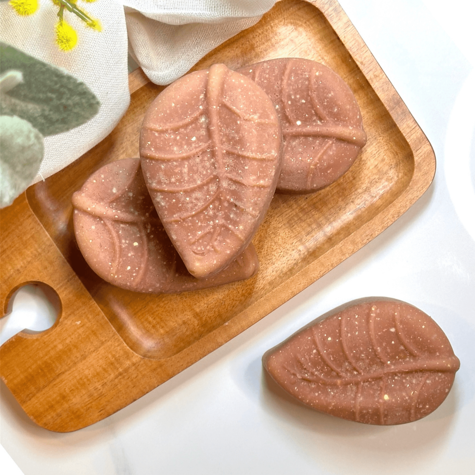 Natural antibacterial sulfur soap for acne, rosacea, and scars, shaped like leaves, placed on an organic wooden tray with botanicals.