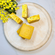 Bright yellow triple turmeric soap bars on a concrete tray with Australian botanicals, featuring organic ingredients and potent turmeric for natural brightening and radiant skin.