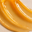 Lightweight translucent golden turmeric lip mask texture with glossy finish