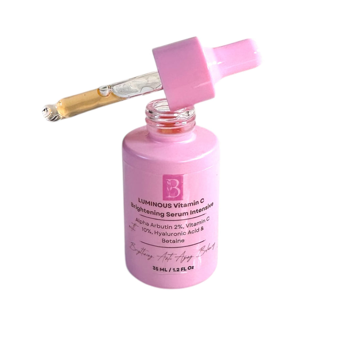 Brightening Vitamin C serum dropper resting on pink bottle – showing lightweight texture and easy application for glowing, even-toned skin.

