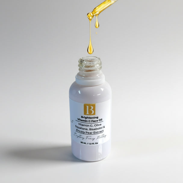 Dropper over serum bottle dispensing light, bright, rich oil into a white bottle, highlighting the luxurious texture of the Vitamin C face oil.