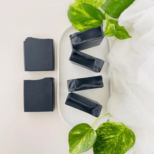 Vibrant black hue detoxifying charcoal soaps. 5 bars with botanicals showcasing all natural soap.