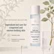 Bubble Clinic Advanced Multi-Acid Blemish Control Toner bottle displayed on a clear acrylic stand, with decorative eucalyptus leaves and a glass on the right, and marketing text on the left against a soft beige background.