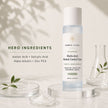 Bubble Clinic Advanced Multi-Acid Blemish Control Toner bottle displayed on a clear acrylic pedestal, surrounded by cosmetic props including glass dishes with leaves and powder, and a small glass beaker, with text detailing the hero ingredients on the left.
