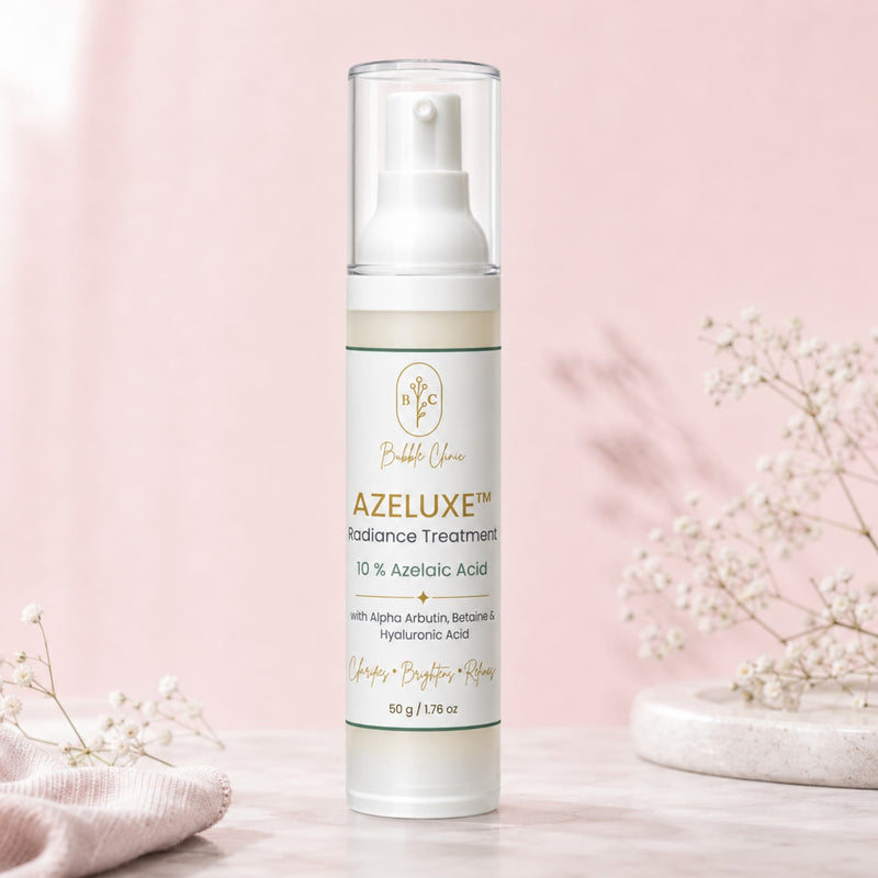 A bottle of Bubble Yours AZELUXE Radiance Treatment stands on a light marble surface against a soft pink background, styled with delicate baby's breath flowers.
