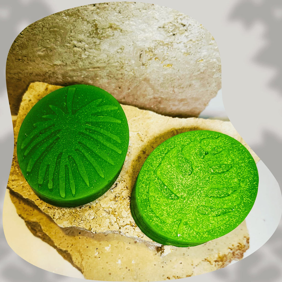 Two green circular soap free salicylic acid cleansers on a rock with a blurred background representing natural skincare for blemishes
