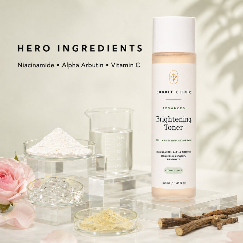Bubble Clinic Advanced Brightening Toner bottle displayed on a clear acrylic stand with cosmetic ingredients, glass beakers, a pink rose, and dried roots highlighting botanical and science backed ingredients.
