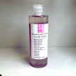 bottle of skin brightening alpha arbutin toner with glycolic acid - against clear background representing natural treatment for dark spots, acne and hyperpigmentation.