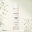 Bubble Clinic Advanced Radiance Toner in a tall frosted bottle with a white cap and muted blush label