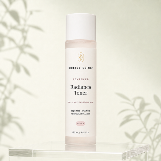 Bubble Clinic Advanced Radiance Toner in a tall frosted bottle with a white cap and muted blush label