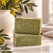 Two Dalan Pirina traditional Turkish olive oil soap bars showing their rustic green finish