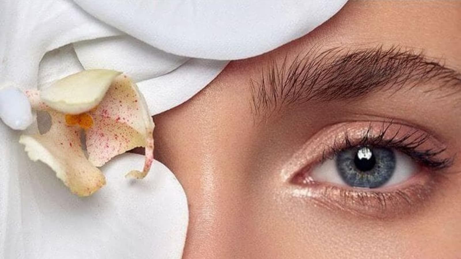 close up of woman's face one eye is covered in natural botanicals representing clean beauty and natural australian skincare.