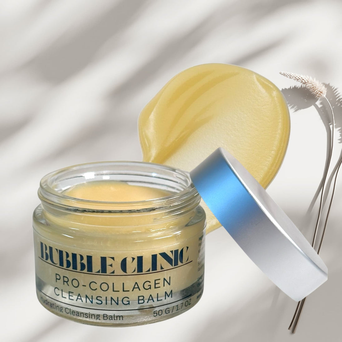 close up of open jar of cleansing balm with swatch of the silky, lightweight balm in the background with botanicals representing natural clean beauty and gentle cleansing routine.