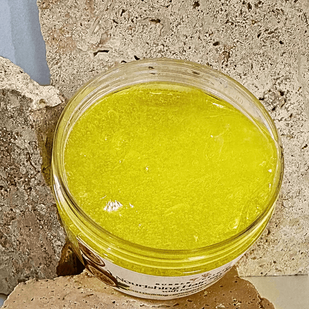 open container of passionfruit kerating hair gel revealing clear, bright yellow gel against natural stone background.