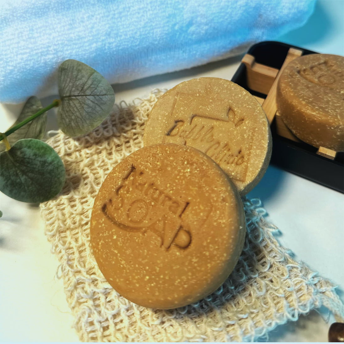 close up of small disc size of emu oil sulphur soap with emu oil and msm with botanicals and natural sisal soap saver in foreground representing all natural Australian Acne and Rosacea skincare.