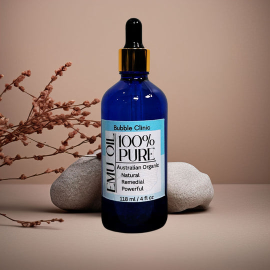 blue glass dropper bottle 100% natural organic Australian Emu Oil organic botanicals in background representing pure organic Australian skincare.