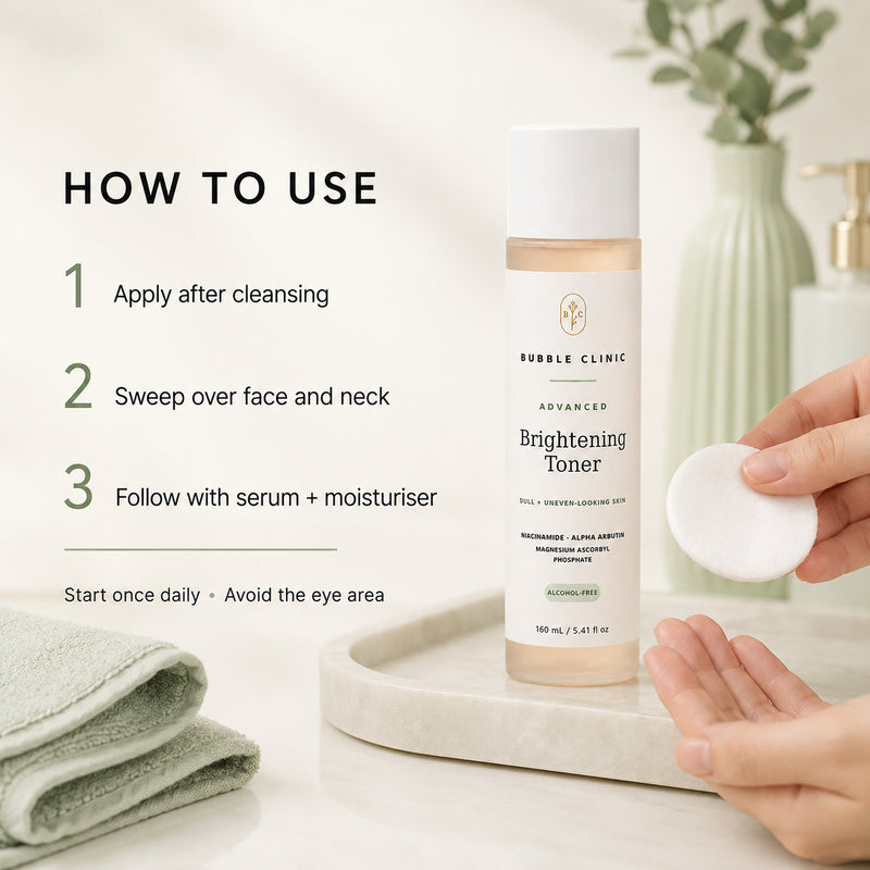 A bottle of Bubble Clinic Advanced Brightening Toner stands on a white tray beside a hand holding a cotton pad, with overlaid usage steps on a soft bathroom-style background.