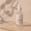 Bubble Clinic Hyaluronic Plumping Serum product on a beige stone background in a 50 mL frosted glass bottle.