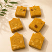 Handmade jumbo turmeric and kojic acid soap bars in golden botanical flat lay