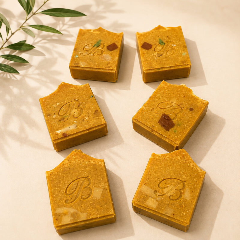 Handmade jumbo turmeric and kojic acid soap bars in golden botanical flat lay