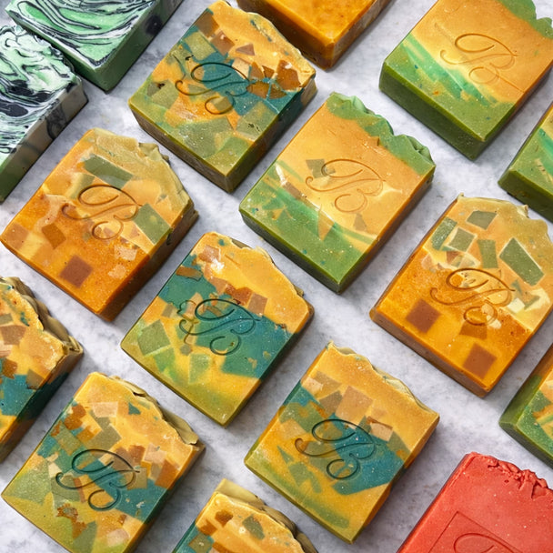 Assorted Turmeric Kojic Acid brightening soap bars with a brand logo on a white background representing best natural brightening skincare Australian Made