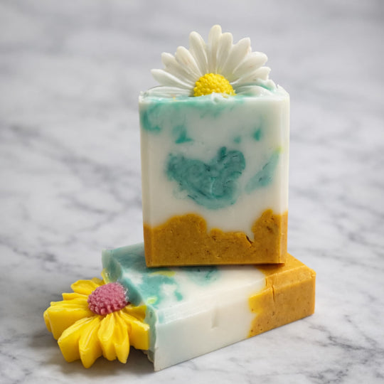 Two Turmeric Kojic natural brightening soap for dark spots with floral design stacked on marble surface representing best brightening soap Australia.