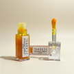 two clear bottles of turmeric lip mask treatment with retinol and squalane for dark lips on beige background representing best natural australian skincare.