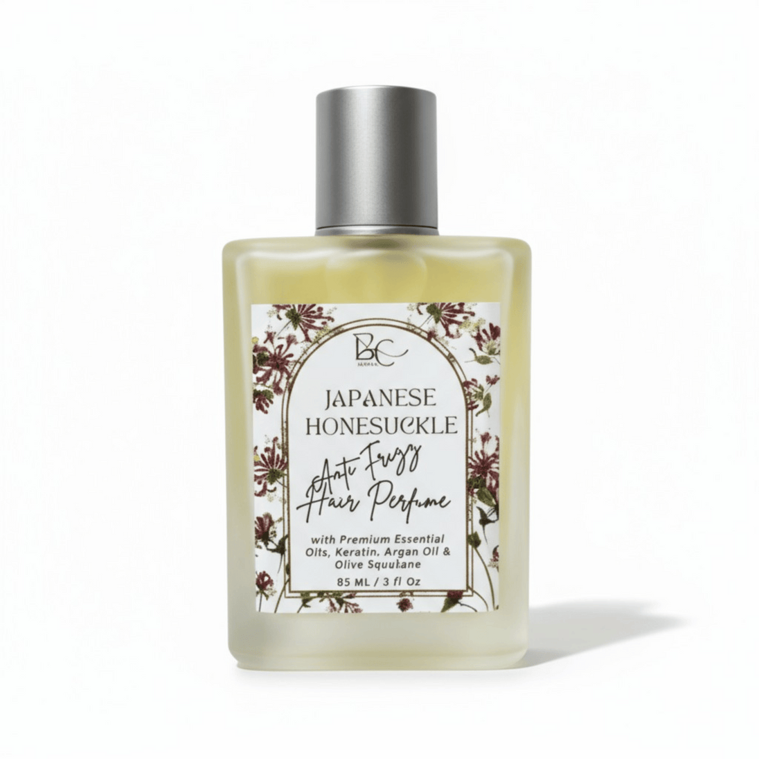 Bottle of luxury hair perfume with keratin, argan oil and Japanese Honeysuckle essential oil with floral label on a white background