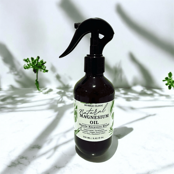 Bottle of natural magnesium oil Magnesium Oil Muscle Recovery Spray – cooling peppermint & eucalyptus aromatherapy with a label on a light background