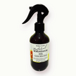Bottle of natural magnesium oil with a black spray nozzle on a white background. the label has images of citrus slices representing the citrusy essenital oil blend.