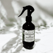 dark bottle of natural magnesium oil with with soothing lavender and chamomile for sleep against white background with shadow reflections from nature representing the best Australian Wellness Care.