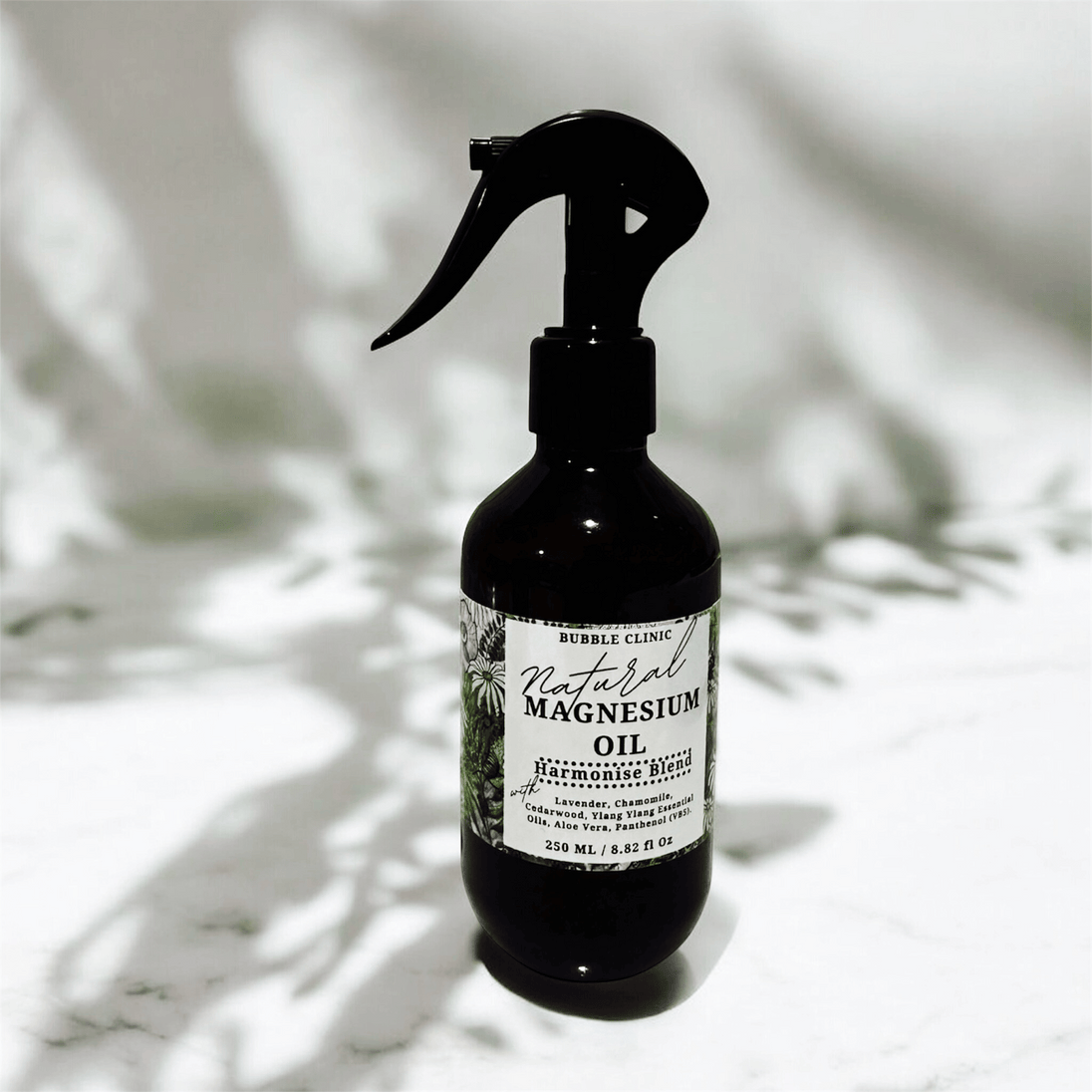 dark bottle of natural magnesium oil with with soothing lavender and chamomile for sleep against white background with shadow reflections from nature representing the best Australian Wellness Care.