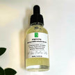 top down photo image of matrixyl 3000 alpha arbutin brightening and anti aging serum against white background with botanicals representing natural clean beauty rituals for bright healthy skin.