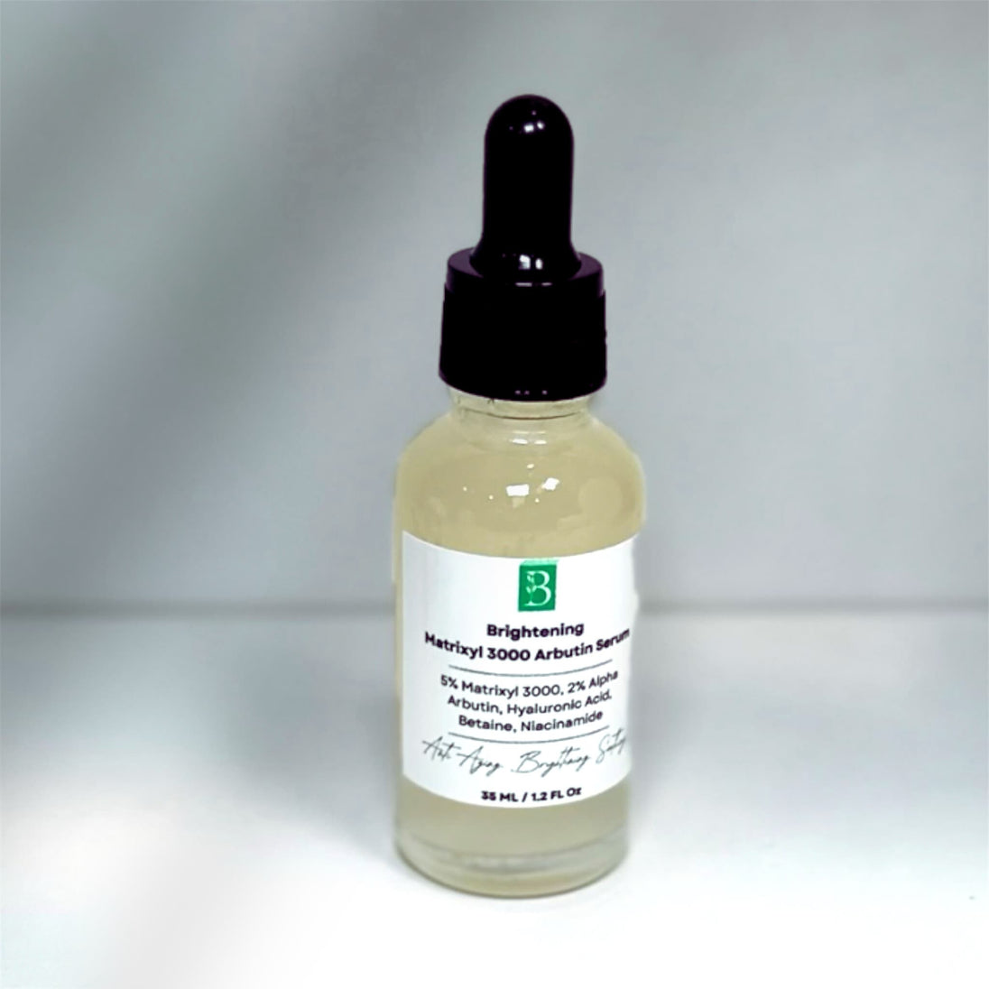 close up of brightening and anti aging matrixyl 3000 serum with alpha arbutin and niacinamide revealing clear light and silky serum for brighter youthful complexion.