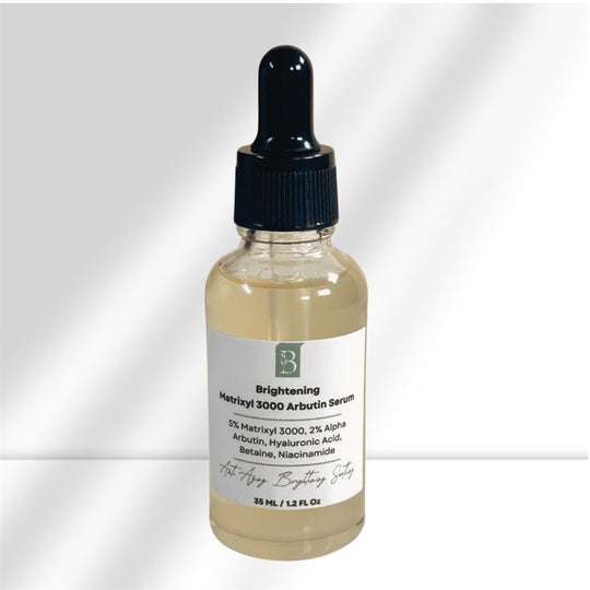 close up of environmentally friendly glass serum bottle of brightening and anti aging matrixyl 3000 and alpha arbutin serum against white background representing natural clean beauty.
