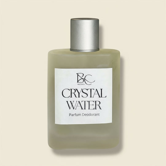 Bottle of Crystal Water parfum deodorant with a silver cap on a light blue background