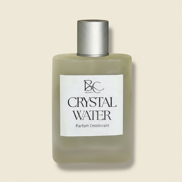 Bottle of Crystal Water parfum deodorant with a silver cap on a light blue background