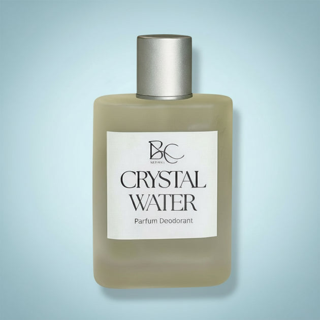 Bottle of Crystal Water parfum deodorant with a silver cap on a light blue background