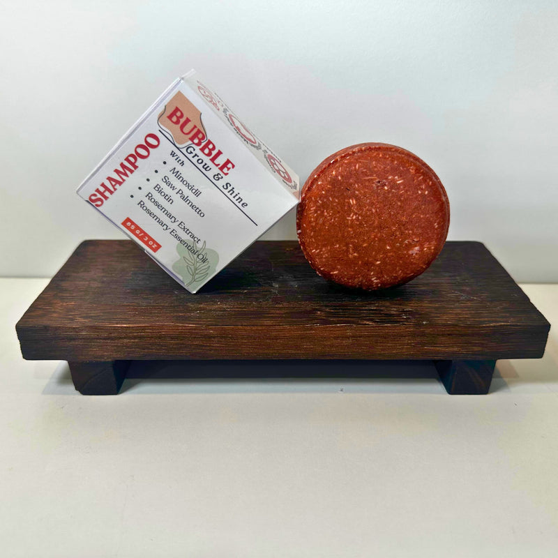 Close-up of Bubble Clinic Minoxidil Shampoo Bar and carton listing minoxidil, biotin, saw palmetto and rosemary.