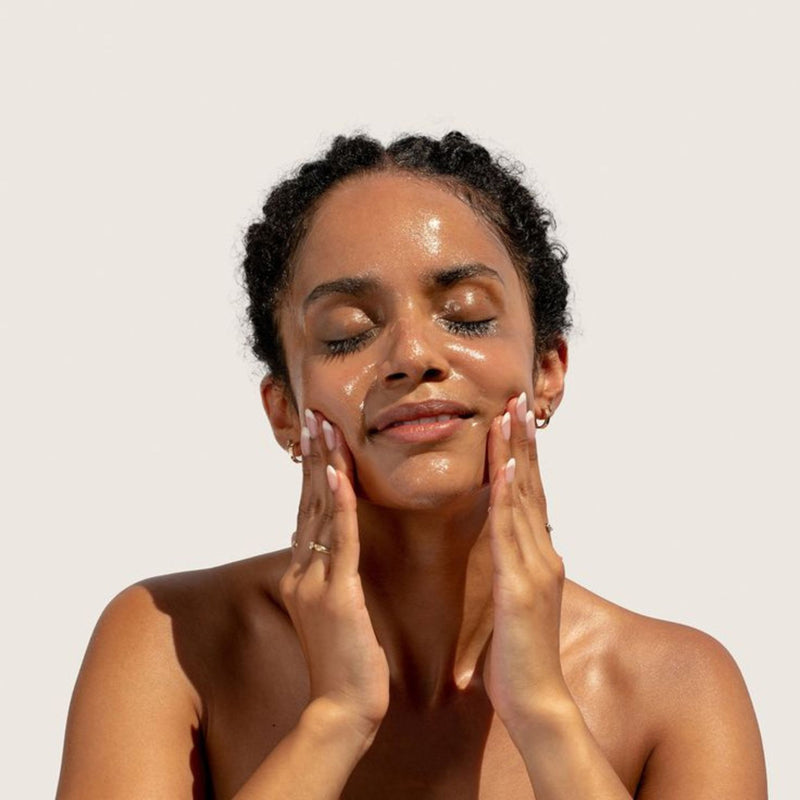 Oil-to-milk cleansing oil being massaged onto the face during a gentle cleansing routine.