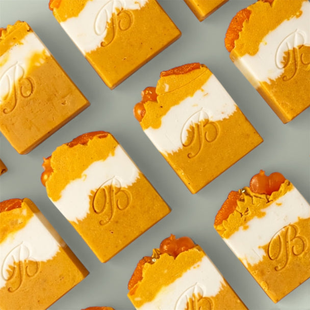 Handmade Kojic Acid Niacinamide Turmeric Soap for hyperpigmentation, acne prone skin and uneven skin tone – Australian made flat laid on green surface