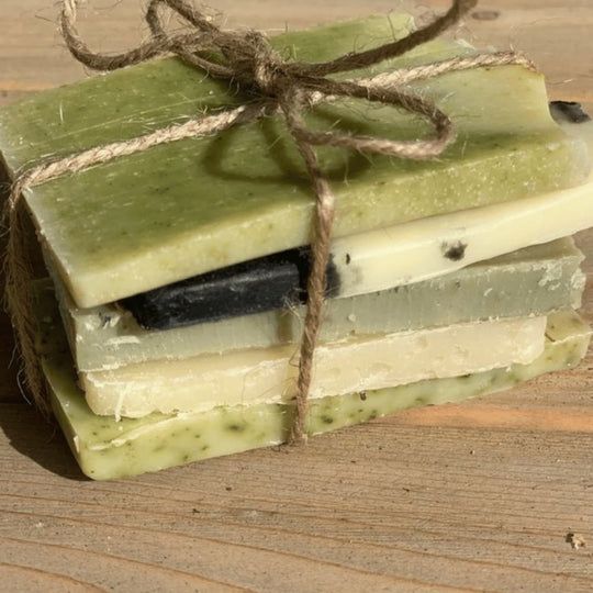 image close up of green soap ends bundle on rustic wooden bench representing organic natural handmade soap