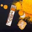 close up of brightening turmeric lip balm with organic honey and turmeric against dark background to highlight beautiful natural colour of organic turmeric and honey.