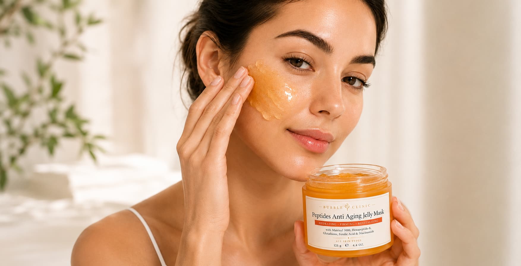 Woman applies Bubble Clinic Peptides Anti Aging Jelly Mask with premium skincare packaging, hydrating overnight jelly face mask formulated with Matrixyl 3000, Acetyl Hexapeptide-8, Glutathione, Ferulic Acid, Niacinamide and Hyaluronic Acid to help visibly firm, hydrate, smooth fine lines and promote radiant-looking skin for all skin types.